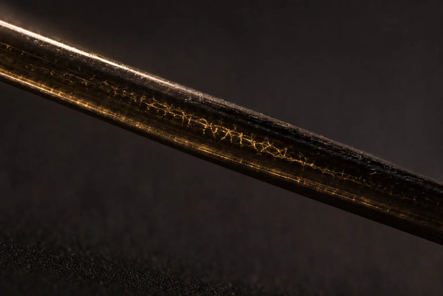 A single hair fibre with internal crosslinks glinting within, disulfide bonds.